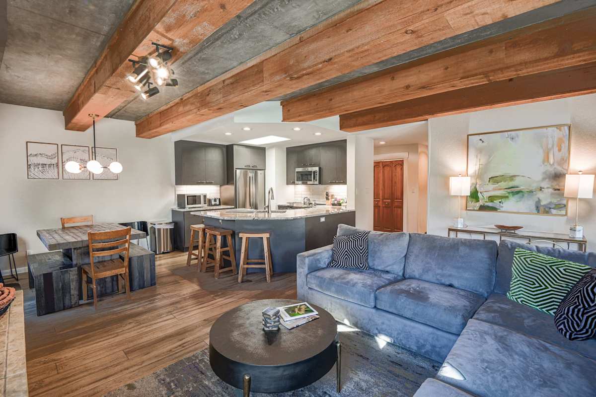 【Living Room】Blue sectional around the fireplace — Mt Crested Butte framed through the window