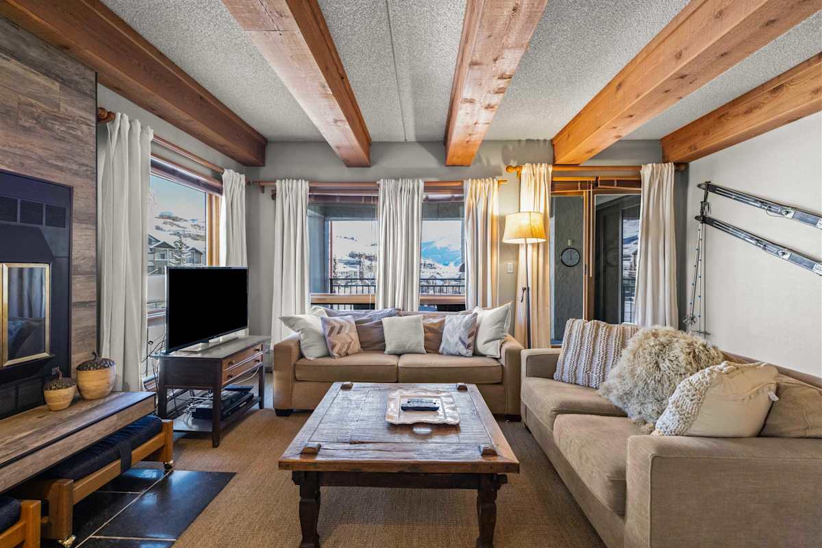【Living Room】Wood-beam ceilings + fireplace + mountain view — where everyone lands after skiing | Listed with @BookTraverse