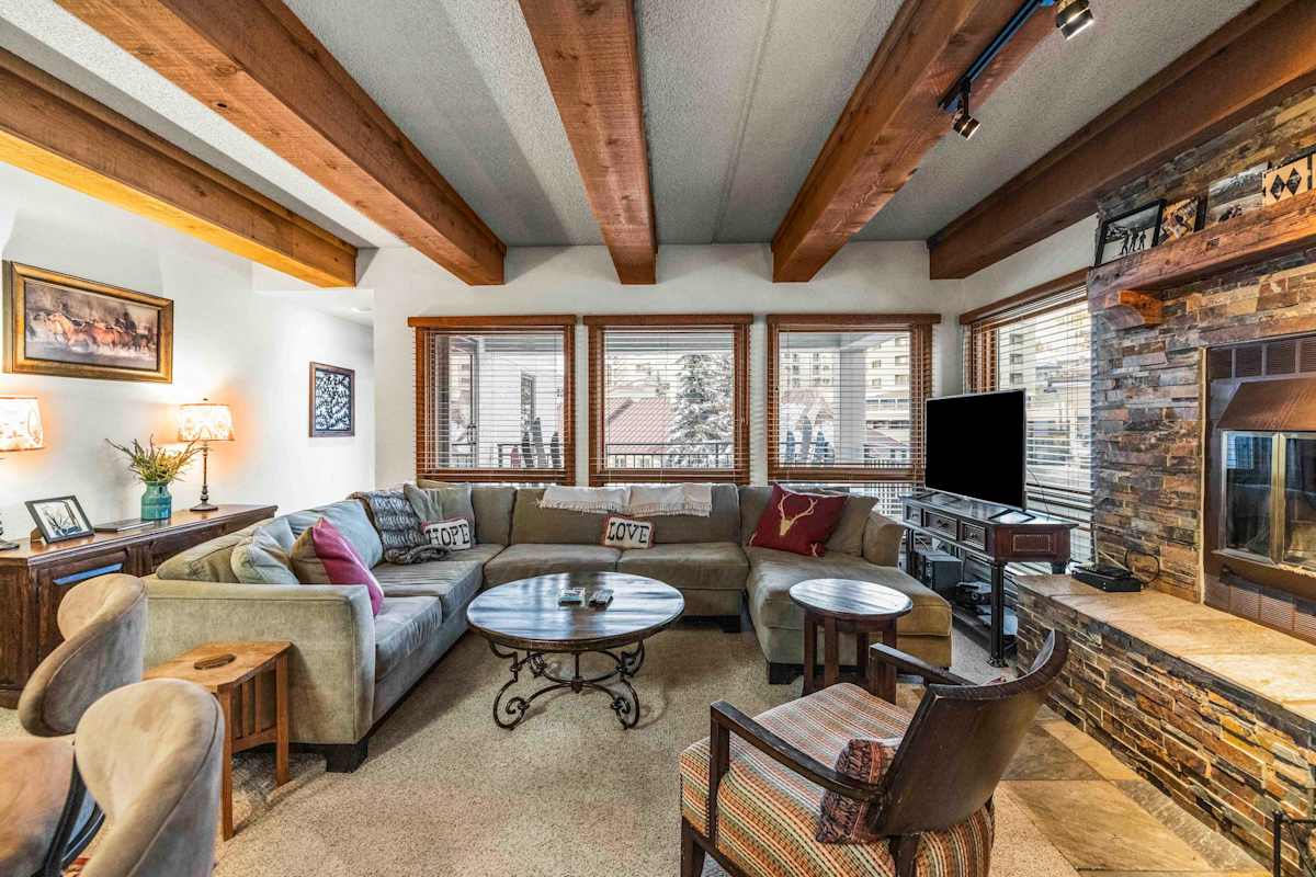 【Living Room】Wood-beam ceilings + fireplace — where everyone lands after skiing