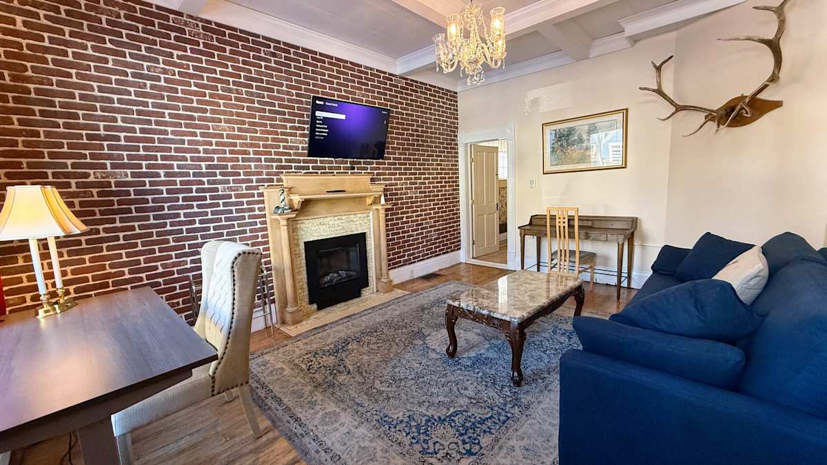 【Living Room】Exposed 1881 brick and an electric fireplace for après-ski movie nights