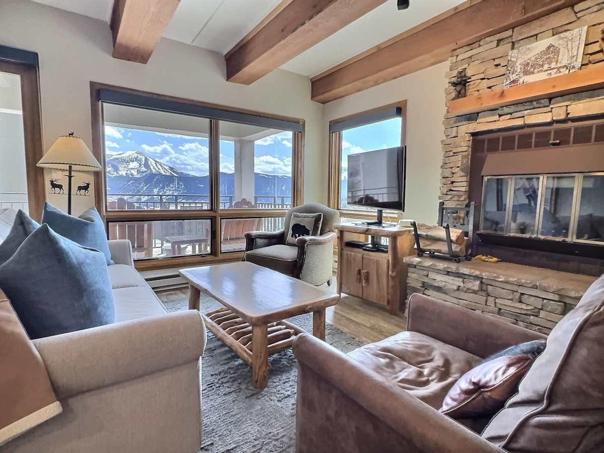 【Living Room】Wood-beam ceilings + fireplace — where everyone lands when the skis come off