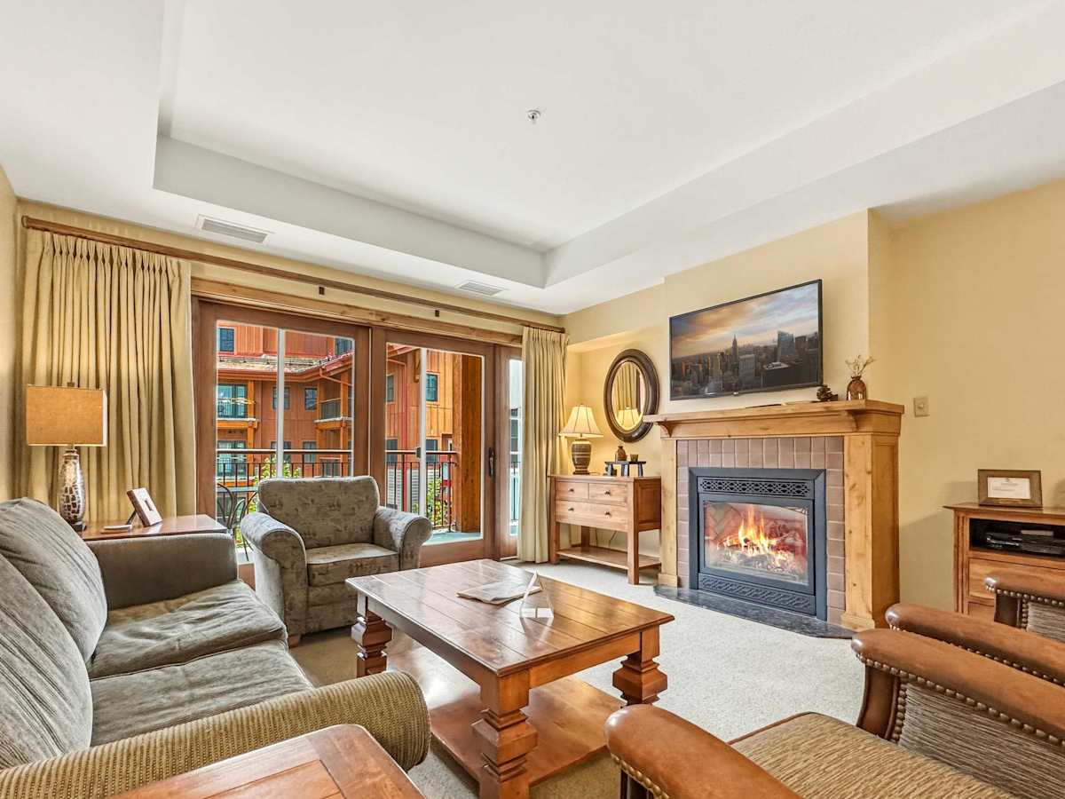 Cozy living room with gas fireplace, smart tv and access to your private large balcony | Listed with @BookTraverse