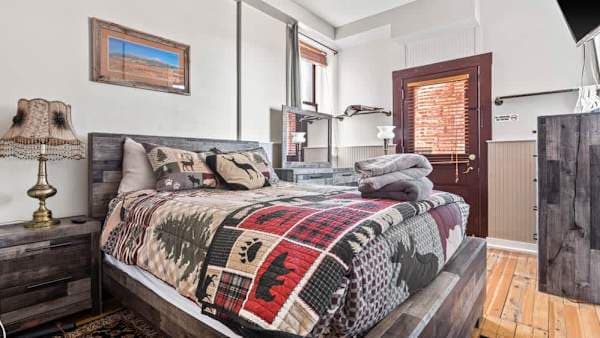 【Bedroom】Queen bed against exposed brick — Smart TV with Netflix + HBO