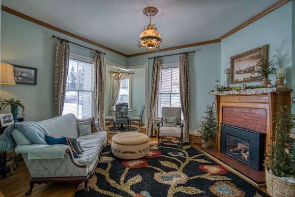 【Living Room】Original Victorian fireplace with antique mantel — where the group lands after the day's ski run.