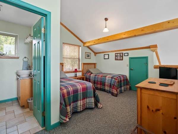 【Loft Bedroom — alt】Loft angle showing both twins and the dormer window — quiet, separated from the main floor.