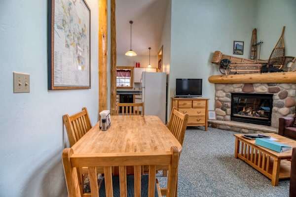 【Dining】Wooden table seats four under mountain-view windows and soaring timber beams.