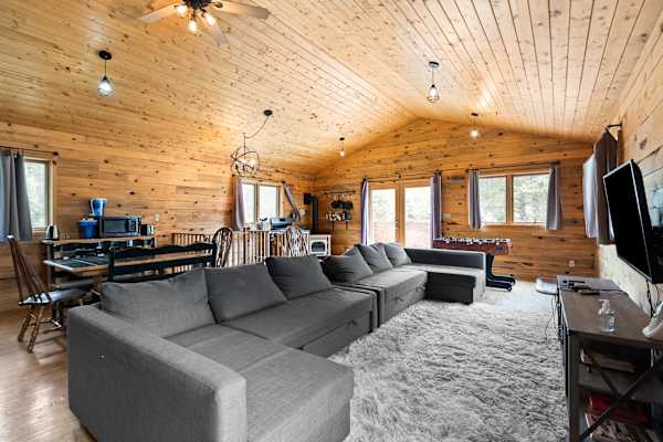 【Upper-Level Great Room】 Gathering space off the deck — stove anchors the far wall