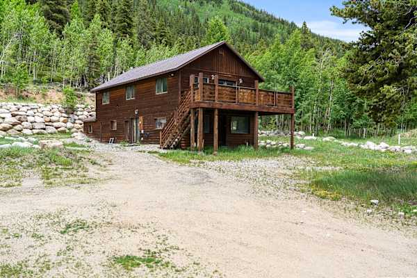 【Winter / Seasonal Exterior】 Snow frames the cabin's log exterior — authentic mountain setting