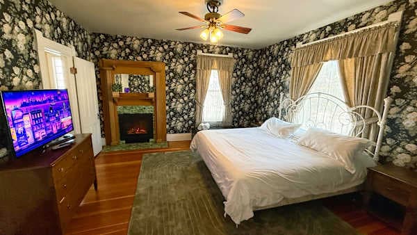 【Bedroom 1】King bed, fireplace, and a jetted tub behind the en-suite door