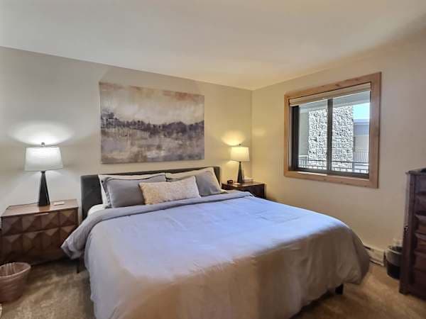【Primary Bedroom】 King bed with ensuite full bath — the main suite of the condo.