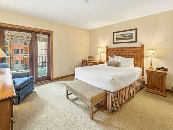 Spacious bedroom with balcony access and ensuite bath | Listed with @BookTraverse